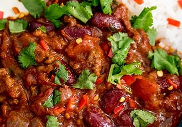 Close-up image of chilli con carne dish with fresh coriander herbs on top