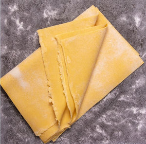 Freshly rolled durum pasta on floured bench