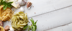 Rolled pasta on wooden bench with garnishes and ingredients