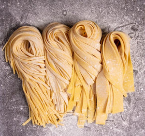Four freshly rolled durum pasta styles cut into different lengths on floured bench at Maria's Pasta