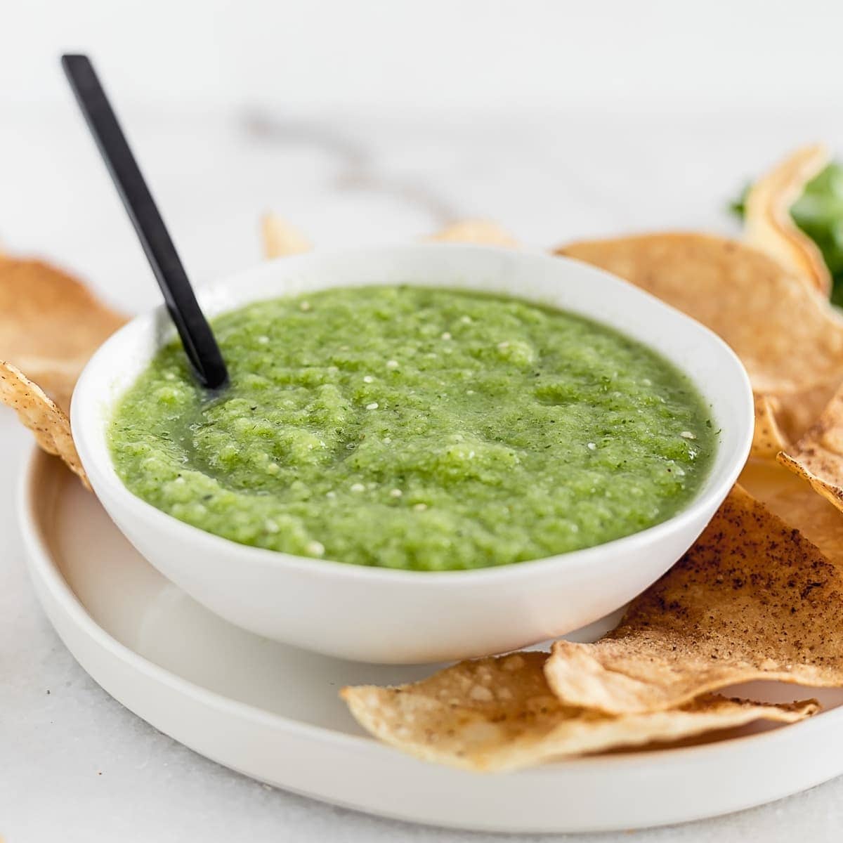 Salsa Verde in white dish with crunchy chips